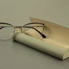 Eleganckie okulary z soczewką asferyczną i fioletowymi oprawkami, obok otwartego etui.