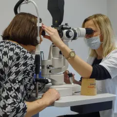 Okulistka bada oko pacjentki za pomocą specjalistycznego sprzętu. To ważny etap w procesie jaskra leczenie.