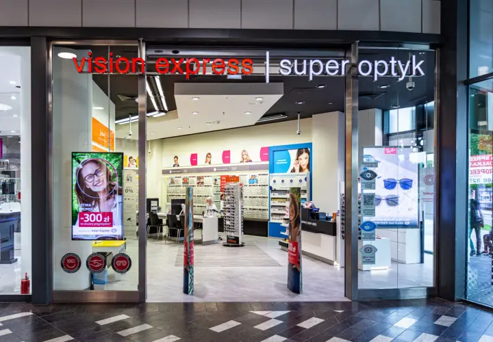 Wejście do salonu Vision Express z ekspozycją okularów i reklamą promocji.