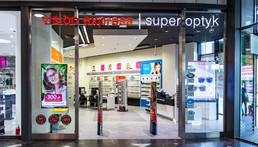 Wejście do salonu Vision Express z ekspozycją okularów i reklamą promocji.