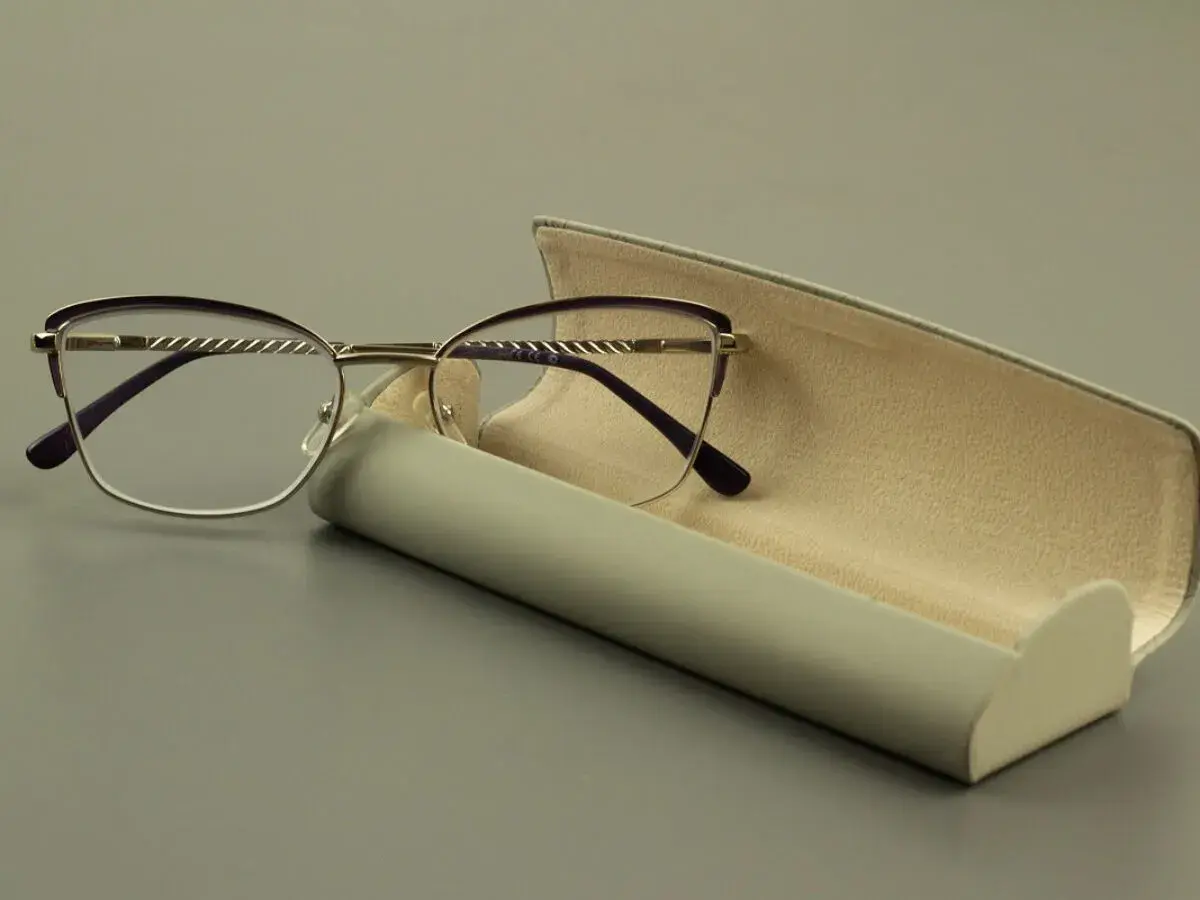 Eleganckie okulary z soczewką asferyczną i fioletowymi oprawkami, obok otwartego etui.